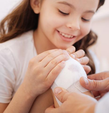 Child receiving first aid after hurting a knee
